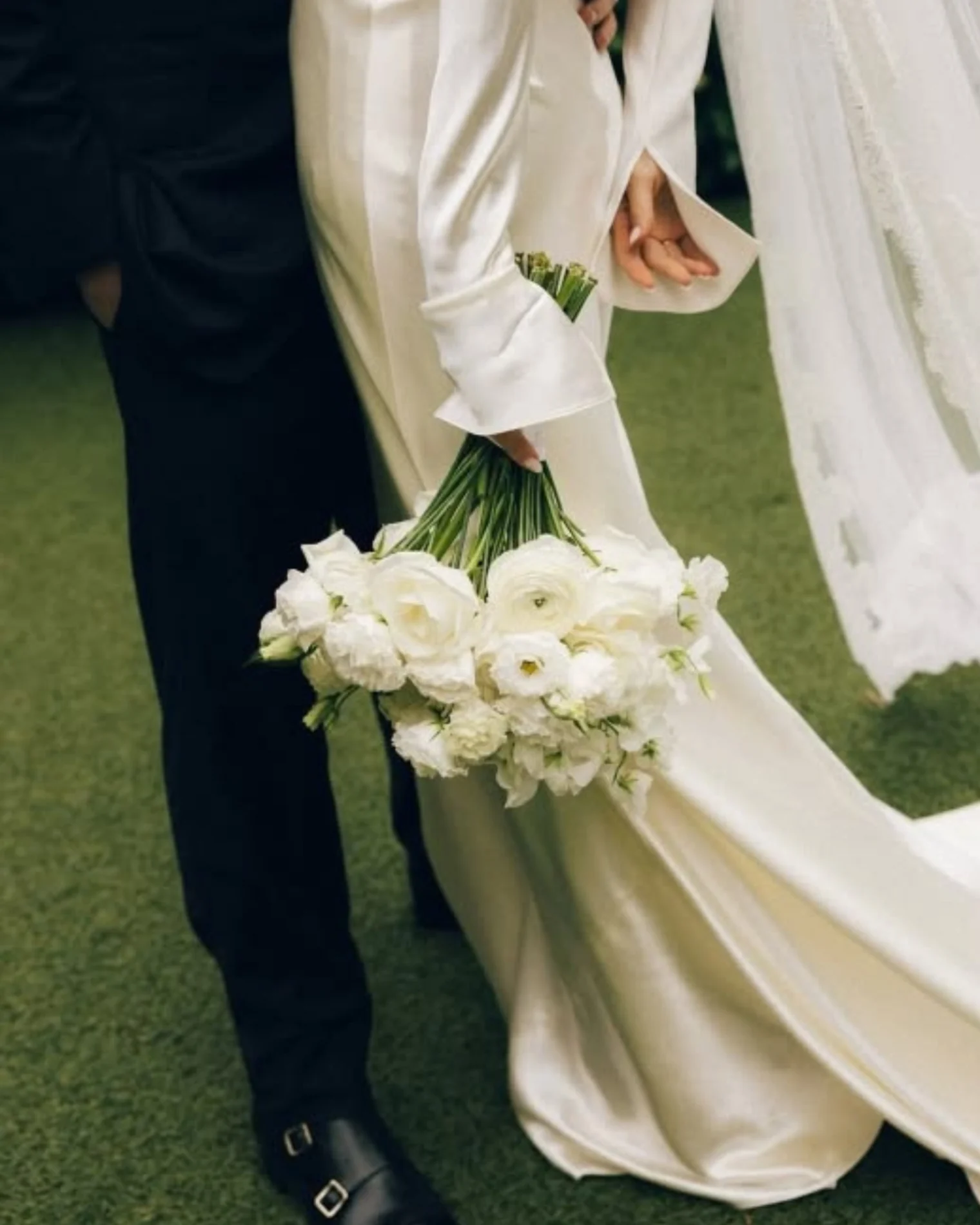 Ramo de flores blancas y detalles del traje de los novios